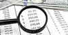 magnifying-glass-over-document-with-financial-data-and-money