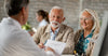 happy-senior-couple-going-through-medical-insurance-paperwork-with-a-doctor