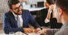 young-businessman-at-desk-couple-signing-a-contract