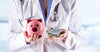 doctor-holding-a-piggy-bank-and-pills