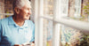 an-elderly-man-looking-through-window